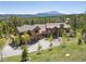 Aerial view of a large home with a stone and wood exterior, mature trees and mountain backdrop at 41 Barton Ridge Dr, Breckenridge, CO 80424