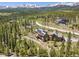 Aerial view showcases a home surrounded by mature trees with mountain views in the distance at 41 Barton Ridge Dr, Breckenridge, CO 80424