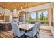 Dining area with wood accents, stylish light fixture, and forest views from the large window at 41 Barton Ridge Dr, Breckenridge, CO 80424