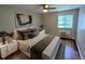 Comfortable bedroom featuring a plush bed with decorative pillows, wood floors, and a window view at 17361 E Mansfield Ave # 532R, Aurora, CO 80013