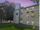 Low angle view of a tan apartment building on a green lawn, with trees and a dusk sky at 17361 E Mansfield Ave # 532R, Aurora, CO 80013