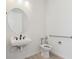 Bathroom features a unique wall-mounted sink, modern faucet, oval mirror and accessible toilet with safety bar at 11481 E Briarwood Cir, Centennial, CO 80112
