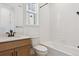 Bathroom with a sink, toilet, and a white tiled tub and shower combination at 11481 E Briarwood Cir, Centennial, CO 80112