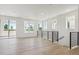 Spacious living room features large windows, sliding glass doors and a modern black railing staircase at 11481 E Briarwood Cir, Centennial, CO 80112