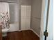 Bathroom featuring a shower/tub combo, wood floors and white door at 1555 California St # 302, Denver, CO 80202