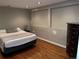 Bedroom with hardwood floors and a gray accent wall with black dresser at 1555 California St # 302, Denver, CO 80202