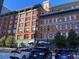 Street-level perspective of a brick building with a view of other residential structures at 1555 California St # 302, Denver, CO 80202