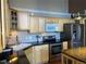 Well-equipped kitchen with stainless steel appliances, light wood cabinets and black countertops at 1555 California St # 302, Denver, CO 80202