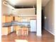 A bright kitchen featuring wood cabinets, an island with seating, and hardwood floors at 1555 California St # 302, Denver, CO 80202
