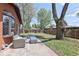 A patio space with outdoor seating, complemented by a large mature tree in a fenced backyard at 8100 W 8Th Ave, Lakewood, CO 80214