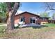 Charming backyard view highlighting brick home, patio with outdoor seating, and mature trees at 8100 W 8Th Ave, Lakewood, CO 80214