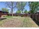 Large backyard enclosed by a wood fence with mature shade trees and sunny areas at 8100 W 8Th Ave, Lakewood, CO 80214