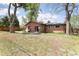 Expansive backyard featuring a brick home with solar panels and a quaint patio seating area at 8100 W 8Th Ave, Lakewood, CO 80214