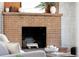 Close-up of a brick fireplace with wood logs and mantel decor at 8100 W 8Th Ave, Lakewood, CO 80214