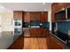 Kitchen boasts stainless steel appliances, wood cabinets, and backsplash with decorative blue tiling at 8100 W 8Th Ave, Lakewood, CO 80214