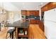 Spacious kitchen with hardwood floors, stainless steel appliances, dark countertops, and a breakfast bar at 8100 W 8Th Ave, Lakewood, CO 80214