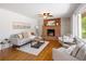 Spacious living room with hardwood floors, a brick fireplace, and natural light from large windows at 8100 W 8Th Ave, Lakewood, CO 80214