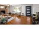 Bright living room featuring hardwood floors, a brick fireplace, and a modern front door at 8100 W 8Th Ave, Lakewood, CO 80214