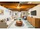 A fully furnished living room in a basement with exposed beams, wood paneling, and modern décor at 8100 W 8Th Ave, Lakewood, CO 80214
