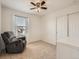 Cozy bedroom with a large chair, closet, and a bright window dressed in flowing curtains at 12734 E 104Th Pl, Commerce City, CO 80022