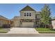 Two-story home boasts a well-maintained lawn, two car garage and a blend of stone and siding accents at 12734 E 104Th Pl, Commerce City, CO 80022