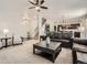The spacious living room has a ceiling fan and seamlessly connects to the dining area and kitchen at 12734 E 104Th Pl, Commerce City, CO 80022