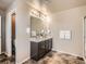 Bright main bathroom features a double sink vanity, modern lighting, and tile floor at 12734 E 104Th Pl, Commerce City, CO 80022