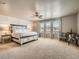 Spacious main bedroom with decorative wall, a large bed, three bright windows, and stylish furnishings at 12734 E 104Th Pl, Commerce City, CO 80022