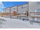 Back view of townhomes featuring private decks and snow-covered yards at 909 Burning Bush Pt, Monument, CO 80132