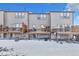 Back view of townhomes featuring private decks and snow-covered yards at 909 Burning Bush Pt, Monument, CO 80132