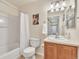 Clean bathroom featuring a shower-tub combo, vanity with wood cabinets, large mirror, and tasteful decor at 909 Burning Bush Pt, Monument, CO 80132