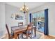 Dining area featuring a wooden table with chairs, chandelier lighting, and sliding glass doors to the backyard at 909 Burning Bush Pt, Monument, CO 80132