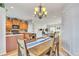 Open-concept dining room featuring a chandelier and wood table and a view of the kitchen and living room at 909 Burning Bush Pt, Monument, CO 80132