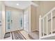 Bright entryway with tile flooring, white staircase, and a double front door with glass panels at 909 Burning Bush Pt, Monument, CO 80132