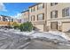 Tan townhome with attached garage, snowy landscape, and driveway at 909 Burning Bush Pt, Monument, CO 80132