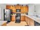 Modern kitchen with wood cabinets, black appliances, and tile backsplash at 909 Burning Bush Pt, Monument, CO 80132