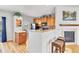 Spacious kitchen featuring wood cabinets, breakfast bar, and access to living room with a fireplace at 909 Burning Bush Pt, Monument, CO 80132