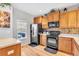 Efficient kitchen with black appliances, wooden cabinets, and a window offering natural light and views at 909 Burning Bush Pt, Monument, CO 80132