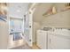 Bright laundry area with front-load washer and dryer, plus convenient storage shelves and access to entry at 909 Burning Bush Pt, Monument, CO 80132