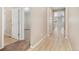 Hallway featuring wood floors and neutral walls connecting to carpeted bedrooms at 15525 Quince Cir, Thornton, CO 80602