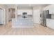 Kitchen area features a gray island, white cabinets, stainless appliances and a subway tile backsplash at 15525 Quince Cir, Thornton, CO 80602