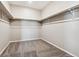 Empty walk-in closet with carpets and white racks for ample storage space at 15525 Quince Cir, Thornton, CO 80602