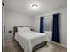 Cozy bedroom featuring a comfortable bed, blue curtains, and a minimalist design for a serene atmosphere at 6055 W Progress Ave, Littleton, CO 80123