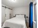 Modern bedroom featuring sliding barn door access to closet, a comfortable bed, and minimalist design at 6055 W Progress Ave, Littleton, CO 80123