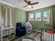 Bright bedroom featuring three windows, ceiling fan, and charming tree-themed wallpaper for a playful ambiance at 6055 W Progress Ave, Littleton, CO 80123