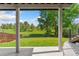 From the covered patio, views of green trees and open fields extend beyond the fenced backyard at 6055 W Progress Ave, Littleton, CO 80123