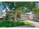 Charming exterior with a well-maintained lawn, mature tree and attached two car garage at 6055 W Progress Ave, Littleton, CO 80123