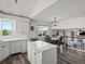 Open kitchen with island, white cabinets, and adjoining dining area with view at 6055 W Progress Ave, Littleton, CO 80123