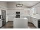 Modern kitchen with white cabinets, stainless steel appliances, and a center island at 6055 W Progress Ave, Littleton, CO 80123