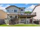 Back exterior of home featuring a two-level deck with stairs leading to a lush green lawn at 6055 W Progress Ave, Littleton, CO 80123